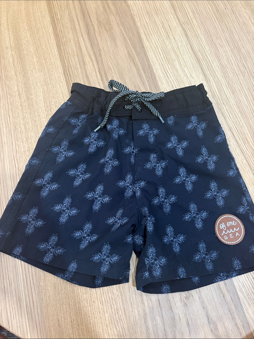 Of One Sea Black swim
Trunks